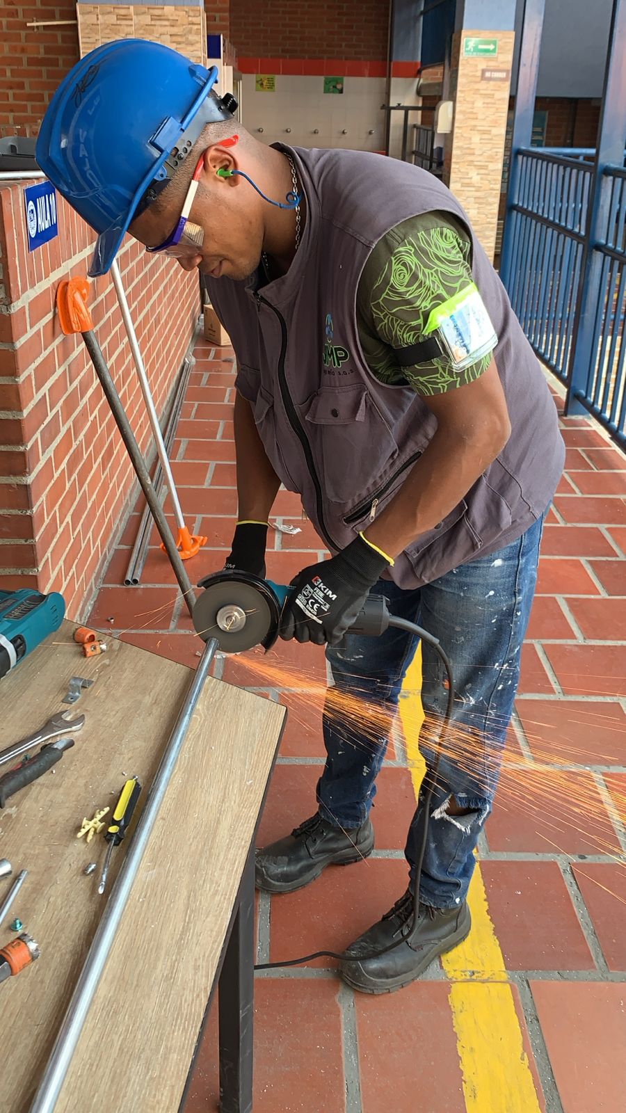 Técnico de JIMP ejecutando una adecuación con casco, gafas, protección auditiva, guantes y botas